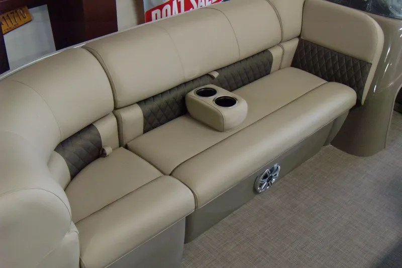 Slide: The Image of 2023 Sun Tracker Party Barge 20 DLX interior with beige seating and cup holders. - 4