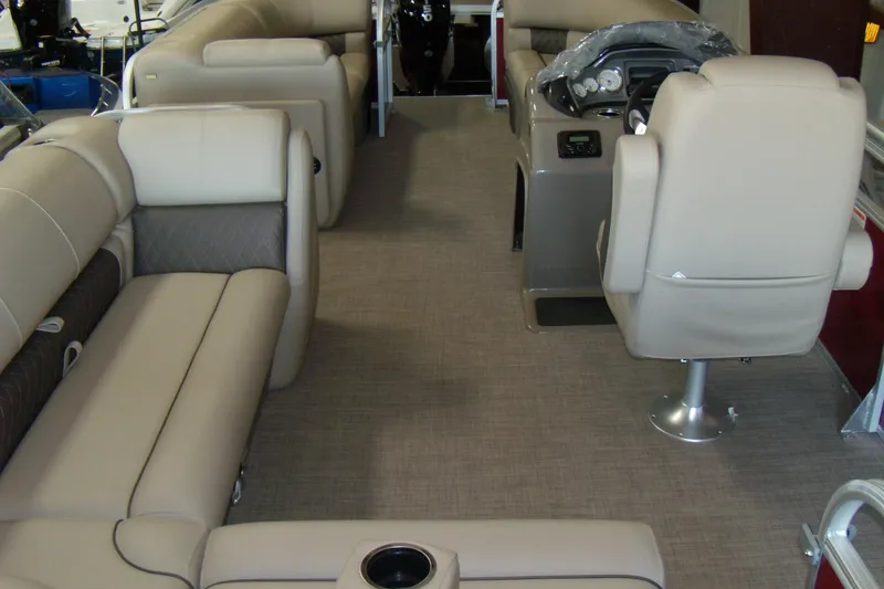 Slide: The Image of 2023 Sun Tracker Party Barge 20 DLX interior with beige seating and steering console. - 5