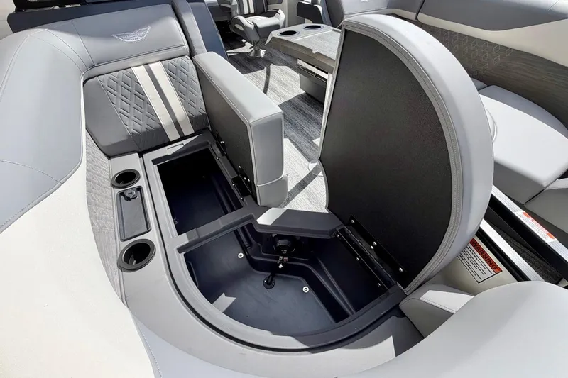 Slide: The Image of 2026 Bennington 23 M Swingback boat interior with open storage compartment and cup holders. - 18