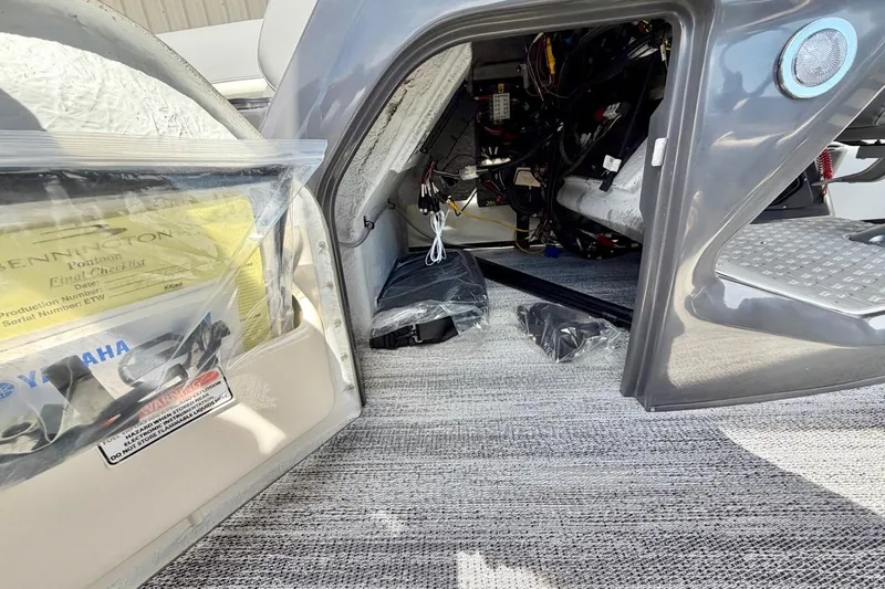 Slide: The Image of Interior view of a 2026 Bennington 23 M Swingback boat showing storage and wiring. - 23
