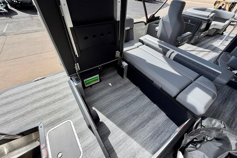 Slide: The Image of 2026 Bennington 23 M Swingback interior with gray seating and storage compartment. - 28