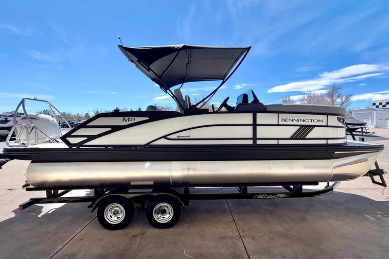 Slide: The Image of 2026 Bennington 23 M Swingback pontoon boat with canopy on trailer, side view. - 7
