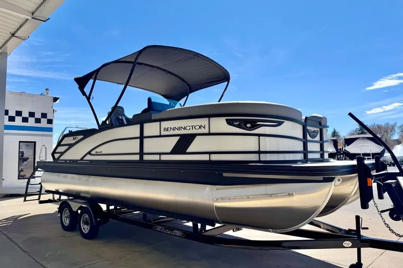 Slide: The Image of 2026 Bennington 23 M Swingback pontoon boat on trailer under blue sky. - 8