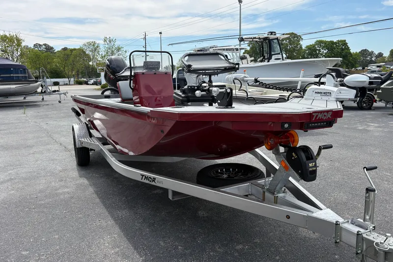 Slide: The Image of Red 2025 Thor Lake Hammer 1900CC Elite boat on trailer, parked outdoors. - 3