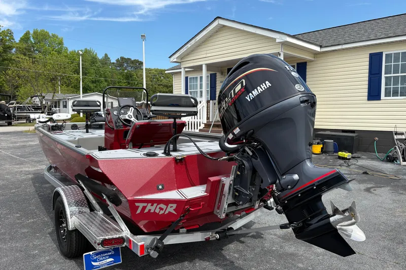 Slide: The Image of Red 2025 Thor Lake Hammer 1900CC Elite boat with Yamaha outboard motor, parked outdoors. - 6