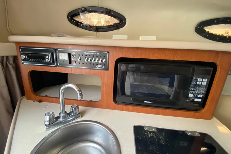Slide: The Image of 2002 Chaparral Signature 240 boat interior with microwave, sink, and control panel. - 22