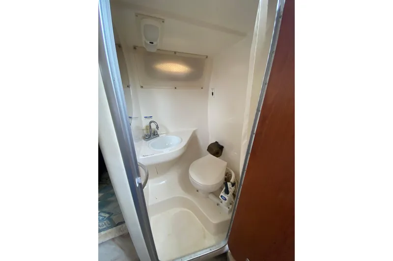 Slide: The Image of Compact bathroom in 2002 Chaparral Signature 240 boat, featuring sink and toilet. - 25