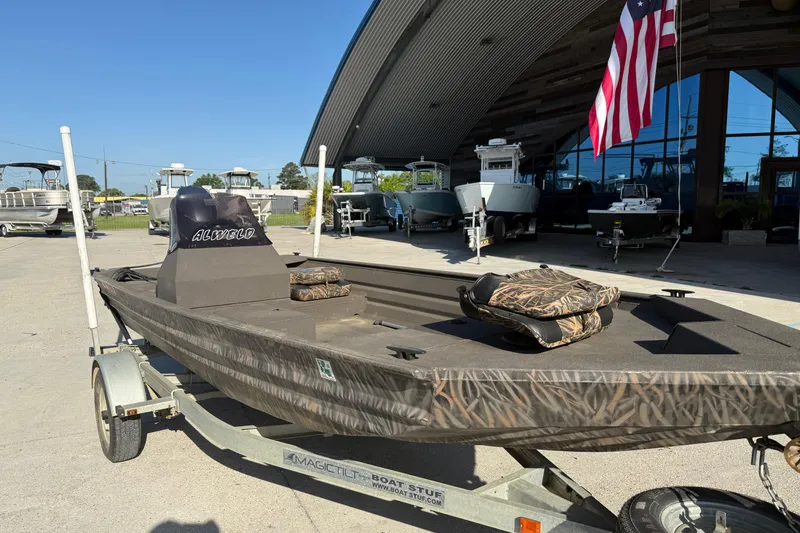 Slide: The Image of 2020 Alweld 1748 Flat Marsh Console SC boat on trailer, displayed outdoors. - 3