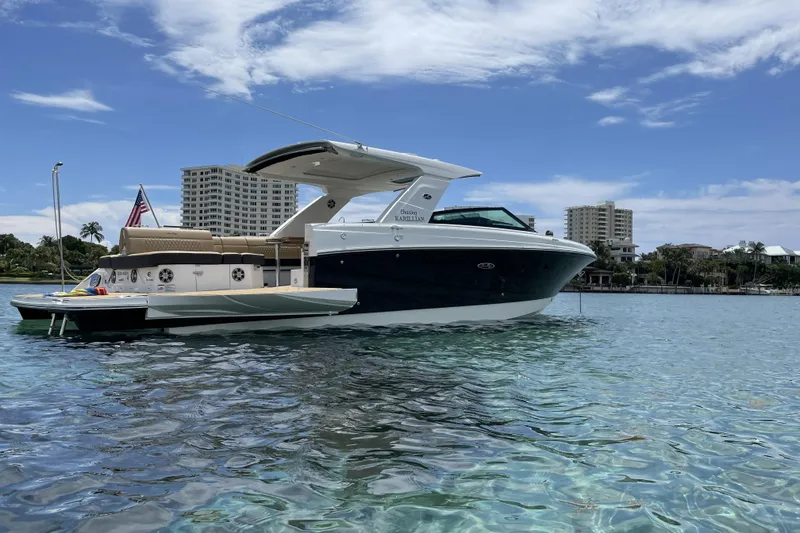 Slide: The Image of 2023 Sea Ray SLX 400 boat on clear water with cityscape background. - 14