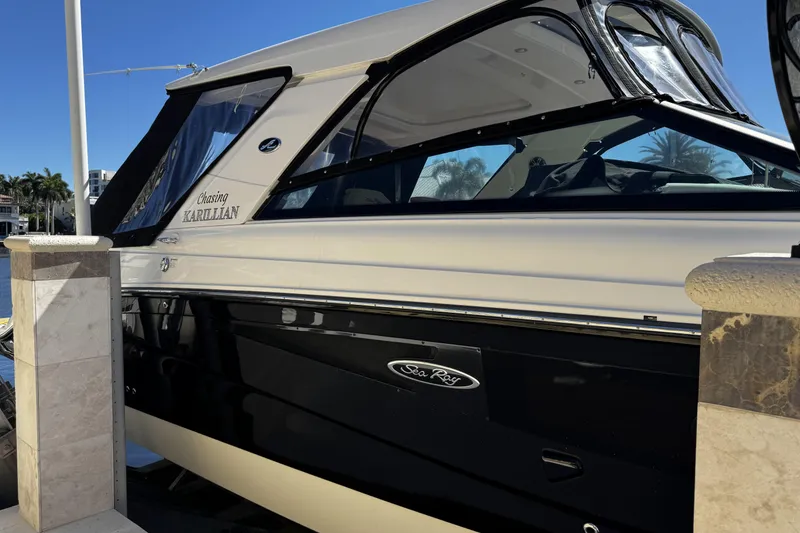 Slide: The Image of 2023 Sea Ray SLX 400 boat docked, featuring sleek black and white design. - 18