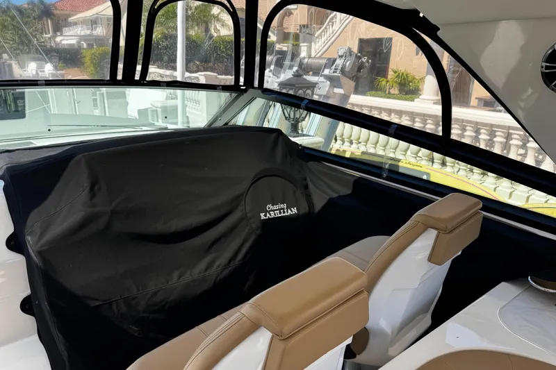 Slide: The Image of 2023 Sea Ray SLX 400 interior with tan seats and protective cover. - 26