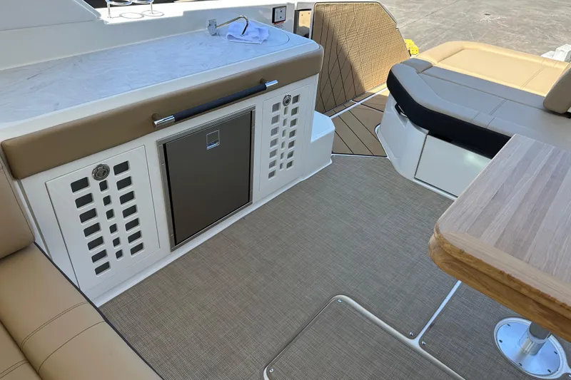 Slide: The Image of 2023 Sea Ray SLX 400 boat interior with seating, table, and storage area. - 39