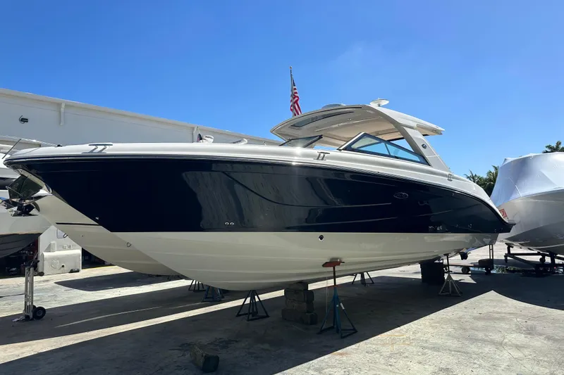 Slide: The Image of 2023 Sea Ray SLX 400 boat on stands, displayed outdoors under clear blue sky. - 4