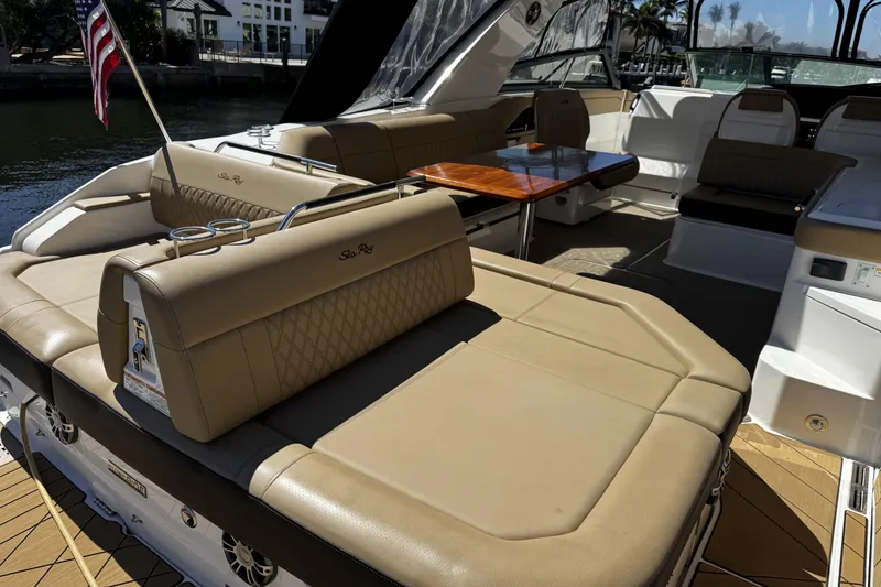 Slide: The Image of Luxurious 2023 Sea Ray SLX 400 boat interior with tan seating and wooden table. - 44