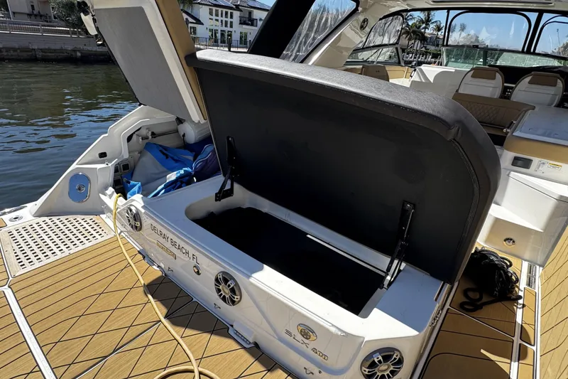 Slide: The Image of 2023 Sea Ray SLX 400 boat with open storage compartment, docked at Delray Beach. - 45