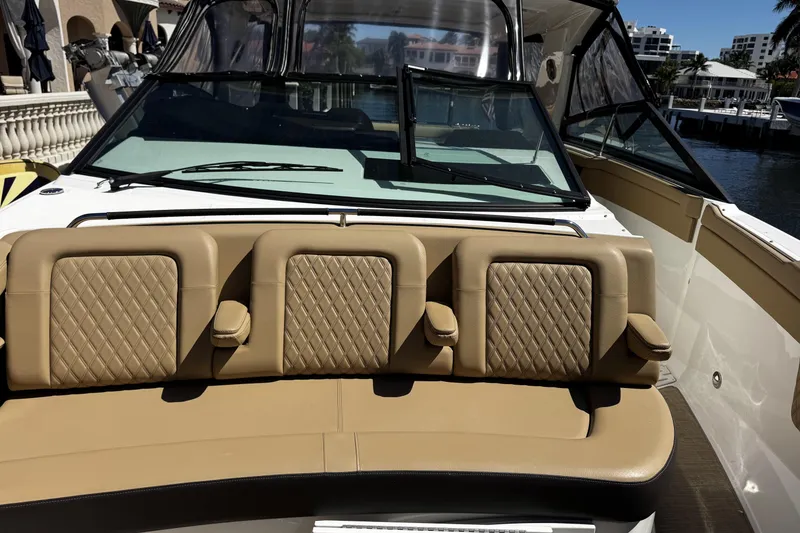 Slide: The Image of 2023 Sea Ray SLX 400 boat with tan leather seating and windshield, docked by waterfront. - 48