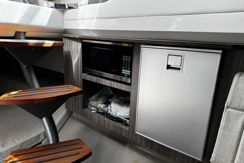Slide: The Image of Interior of 2023 Sea Ray SLX 400 yacht with microwave and mini fridge. - 58