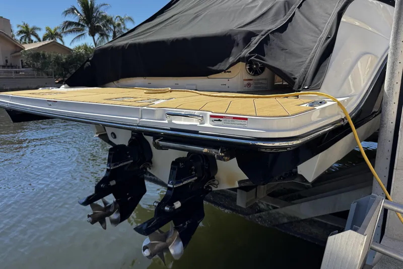 Slide: The Image of 2023 Sea Ray SLX 400 boat with covered deck and dual propellers, docked by the water. - 64
