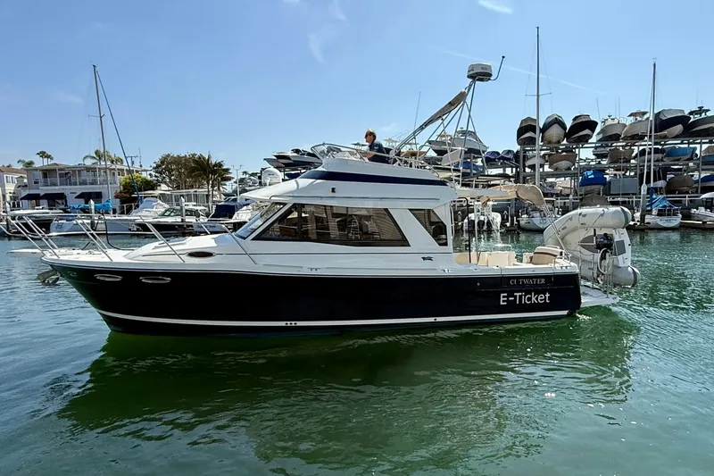 Slide: The Image of 2015 Cutwater C-30 CB boat docked in a marina, surrounded by other vessels. - 11