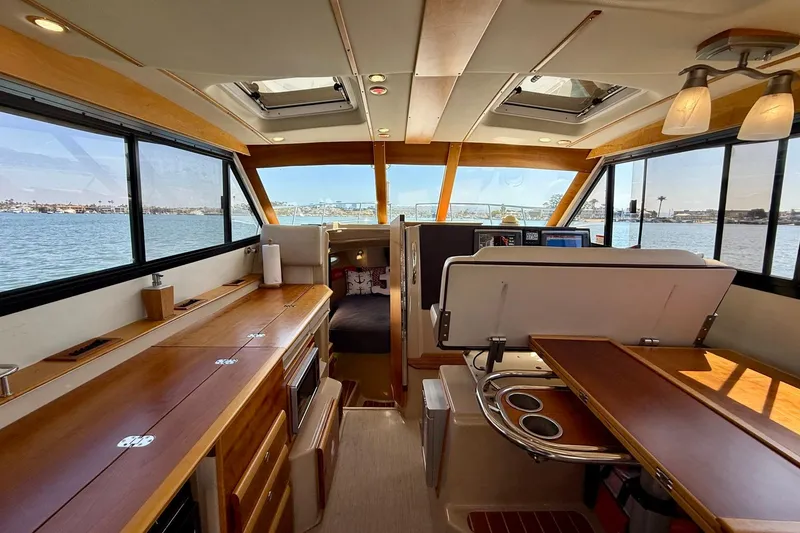 Slide: The Image of Interior of 2015 Cutwater C-30 CB boat with wood finishes and scenic water view. - 12
