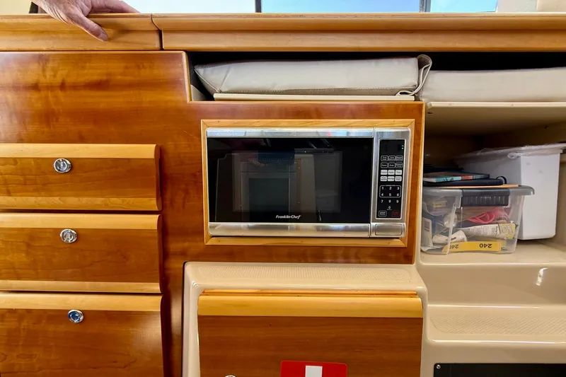Slide: The Image of Interior of 2015 Cutwater C-30 CB with microwave and wooden cabinetry. - 14