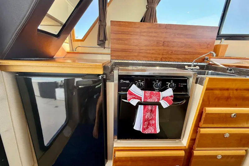 Slide: The Image of Interior of 2015 Cutwater C-30 CB boat featuring kitchen with stove and sink. - 23