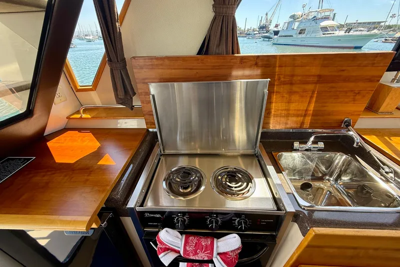 Slide: The Image of 2015 Cutwater C-30 CB yacht kitchen with stove, sink, and wooden countertops. - 24