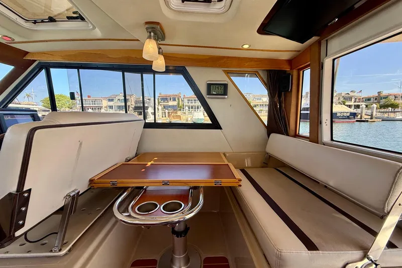 Slide: The Image of Interior of 2015 Cutwater C-30 CB boat with seating and table, overlooking marina. - 28