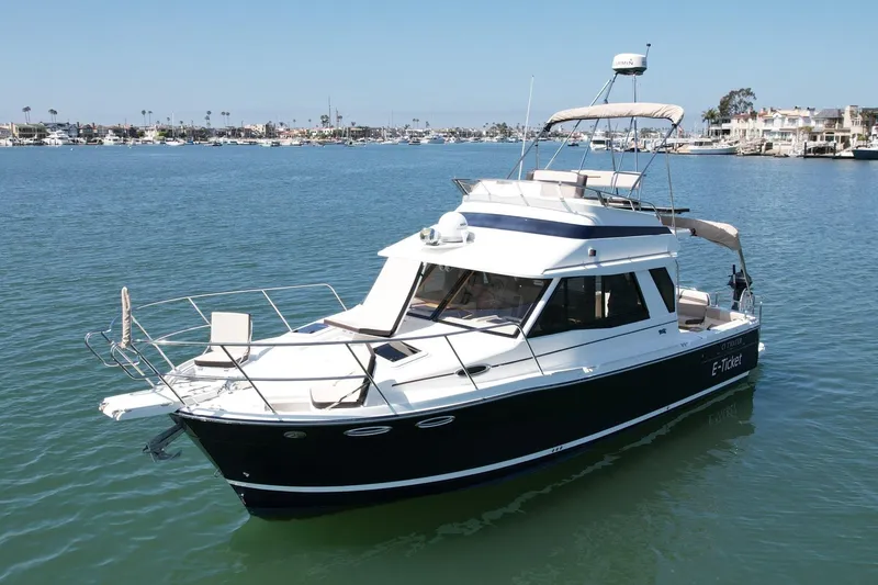 Slide: The Image of 2015 Cutwater C-30 CB boat on calm water, featuring sleek design and spacious deck. - 3