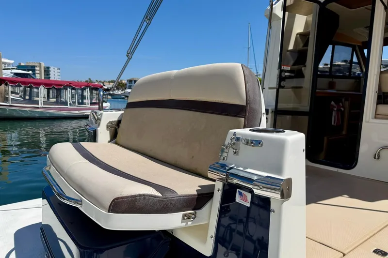 Slide: The Image of 2015 Cutwater C-30 CB boat with beige seating, docked in a marina under clear blue skies. - 73