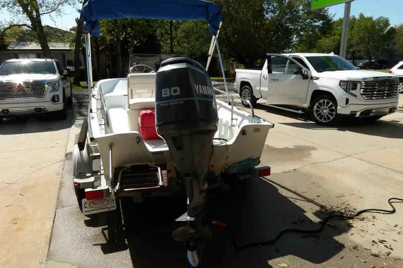 Slide: The Image of 1982 Boston Whaler Montauk 17 CC with Yamaha 80 engine on trailer, parked near trucks. - 11