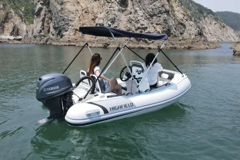 Slide: The Image of Manufacturer Provided Image: 2023 Highfield Sport 330 inflatable boat on water with Yamaha outboard motor. - 11