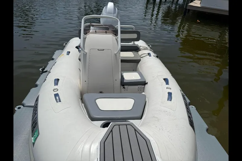 Slide: The Image of 2019 Highfield Sport 330 inflatable boat docked on calm water. - 2