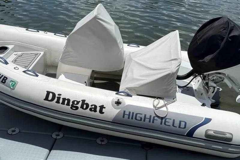 Slide: The Image of 2019 Highfield Sport 330 inflatable boat named "Dingbat" docked on water. - 6