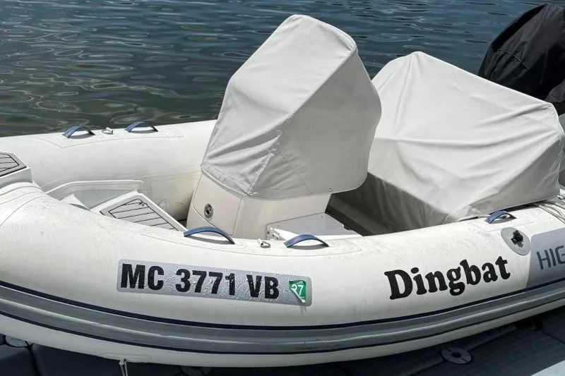 Slide: The Image of 2019 Highfield Sport 330 inflatable boat named "Dingbat" docked on calm water. - 7