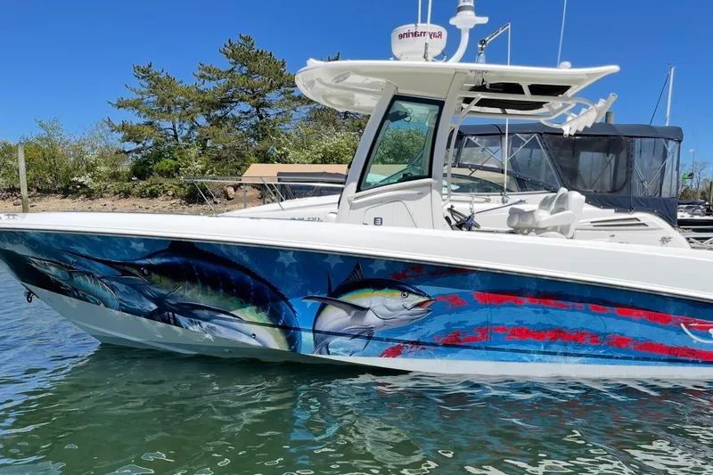 The Image of 2014 Boston Whaler 280 Outrage with vibrant fish-themed hull artwork, docked in sunny marina. - 0