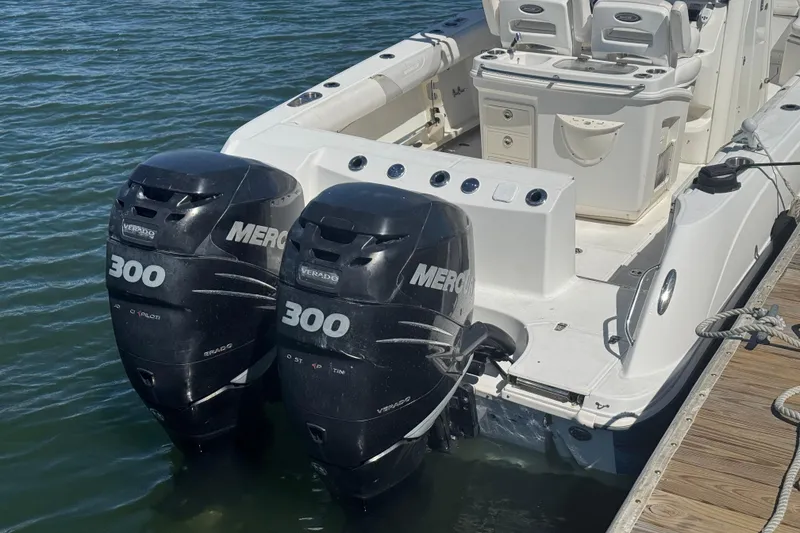 Slide: The Image of 2014 Boston Whaler 280 Outrage with twin Mercury 300 engines docked by the water. - 14