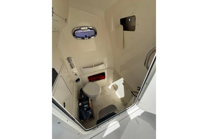 Slide: The Image of Interior cabin of 2014 Boston Whaler 280 Outrage, featuring a compact marine toilet. - 4