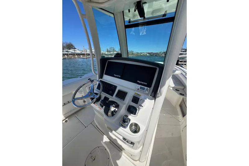 Slide: The Image of 2014 Boston Whaler 280 Outrage helm with steering wheel and navigation controls. - 5