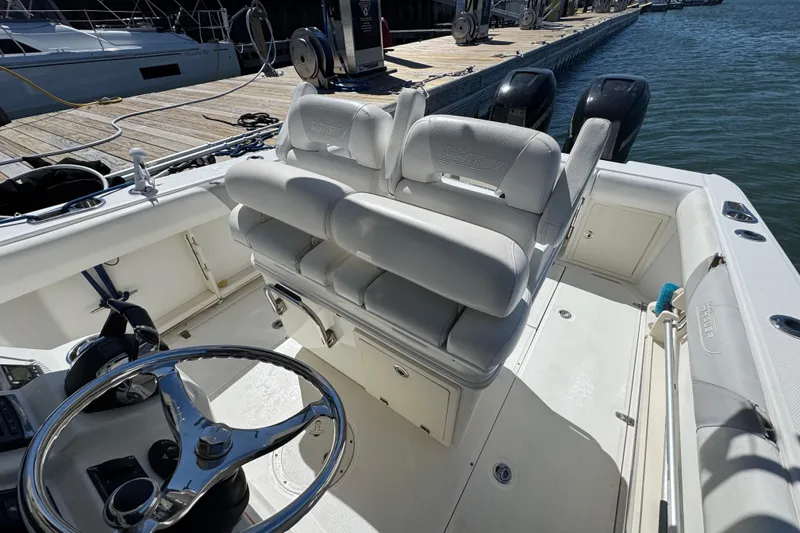 Slide: The Image of 2014 Boston Whaler 280 Outrage boat interior with helm and seating at dock. - 9