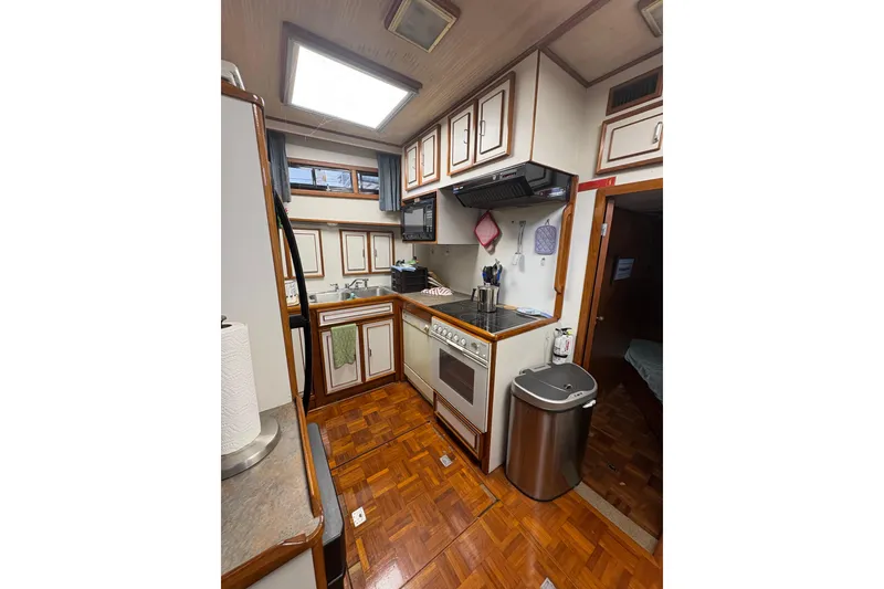 Slide: The Image of 1989 Jefferson 60' Marquessa Motor Yacht kitchen with wood flooring and modern appliances. - 15