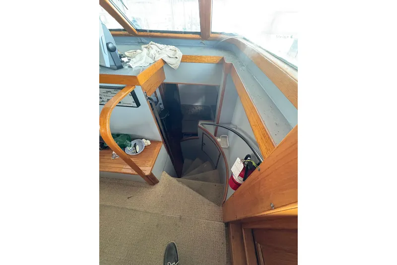 Slide: The Image of Staircase inside 1989 Jefferson 60' Marquessa Motor Yacht with wooden railings and carpeted steps. - 21