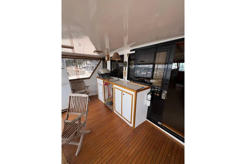 Slide: The Image of 1989 Jefferson 60' Marquessa Motor Yacht interior with wooden deck and seating area. - 25