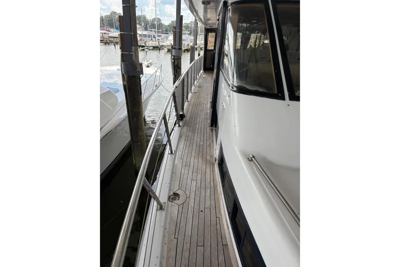 Slide: The Image of 1989 Jefferson 60' Marquessa Motor Yacht docked, showcasing sleek deck and railing design. - 4