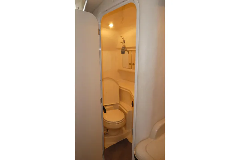 Slide: The Image of 2005 Sea Ray 340 Sundancer bathroom interior with toilet and storage cabinets. - 18