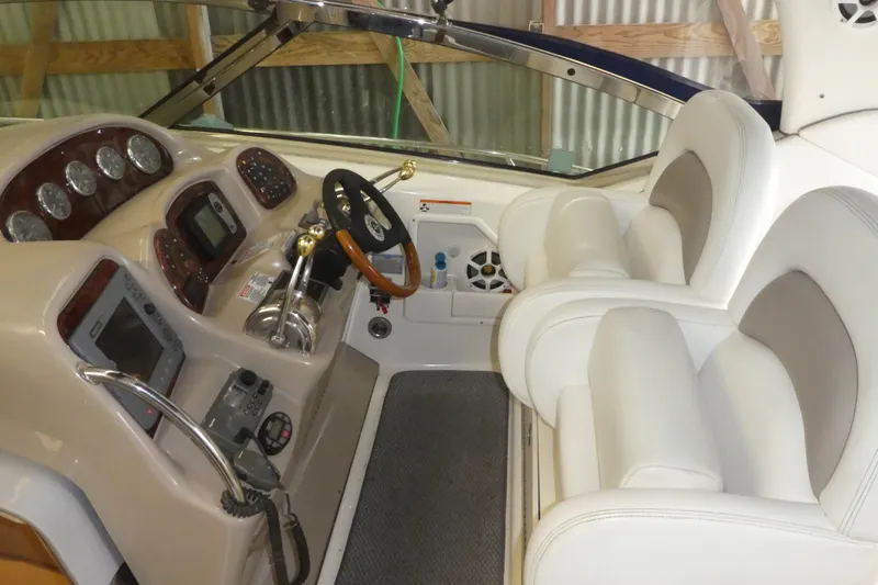 Slide: The Image of Interior cockpit of a 2005 Sea Ray 340 Sundancer with white seating and control panel. - 4