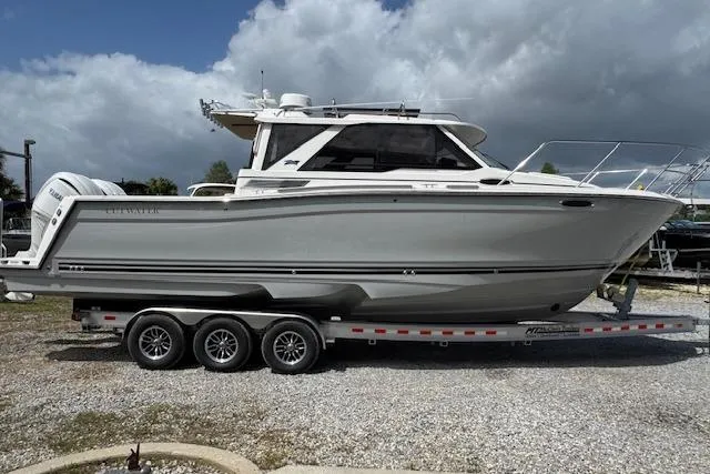 Slide: The Image of 2026 Cutwater C-288 Coupe boat on trailer under cloudy sky. - 11