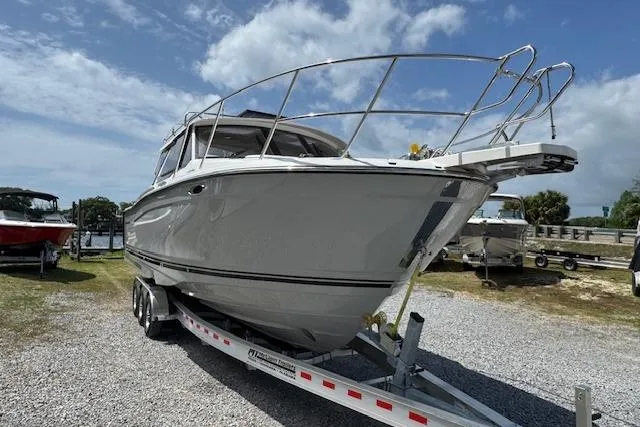 Slide: The Image of 2026 Cutwater C-288 Coupe boat on trailer under a partly cloudy sky. - 2