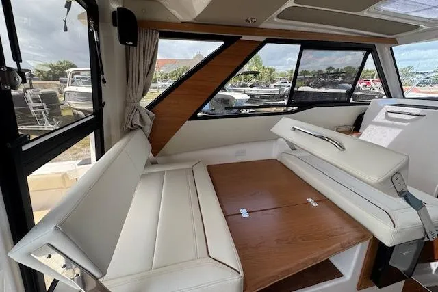 Slide: The Image of Interior of 2026 Cutwater C-288 Coupe with white seating and wooden table. - 21