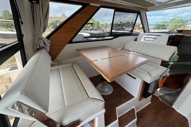 Slide: The Image of Interior of 2026 Cutwater C-288 Coupe featuring a modern dining area with white seating. - 22